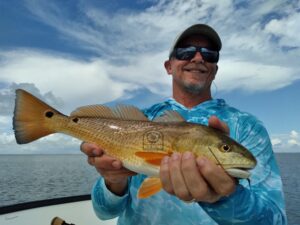 Happy Fly Fishing Angler Cameron holds a Texas pumpkin redfish