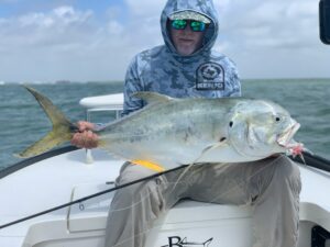Angler on guided fly fishing trip in Port Aransas holds a est. 35lb jack crevelle in the Bay
